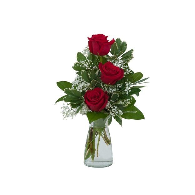Simple floral arrangement featuring three red roses, white filler flowers, and green leaves in a vase.